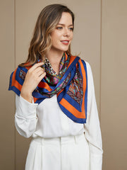 Woman wearing a vibrant mulberry silk square scarf with blue, orange, and bohemian paisley patterns.