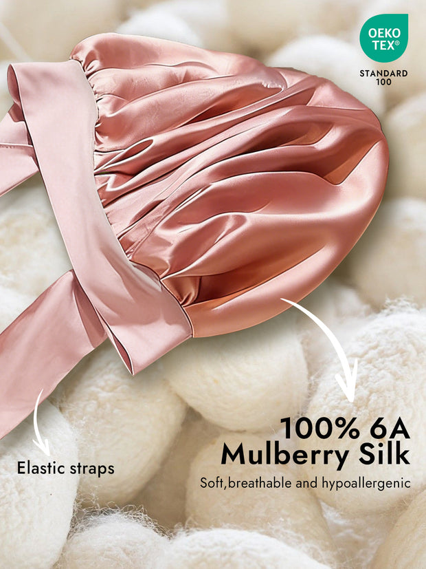Pink mulberry silk bonnet with elastic tie straps, soft and breathable.