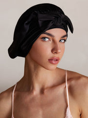 Black mulberry silk bonnet with a bowknot tie, protecting hair while sleeping.