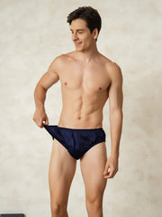 Men's navy blue mulberry silk briefs with elastic waistband, worn by a smiling man.