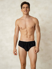 Men's black mulberry silk briefs with elastic waistband worn by a smiling man.