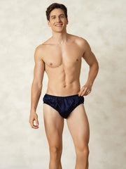 Men's navy blue mulberry silk briefs with elastic waistband, worn by a smiling model.