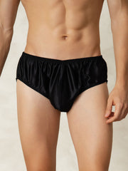Men's black mulberry silk briefs with elastic waistband, shown on a model.