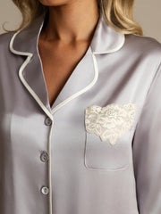 Women's mulberry silk button-up nightshirt in grey with white piping and lace pocket detail.
