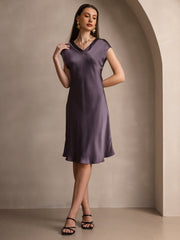 Mulberry silk cap sleeve V-neck knee dress in a rich purple hue, worn by a woman.