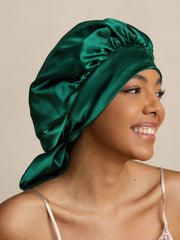 Emerald green mulberry silk bonnet with long ribbons on a smiling woman.
