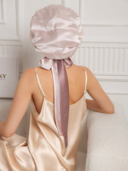 Two-tone mulberry silk bonnet with long ribbons, worn by a woman in a silk nightgown.