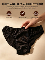 Black 100% Mulberry silk classic bikini panty with a small bow, held by a hand.