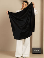 Elegant woman holding a classic black 100% mulberry silk square scarf (90x90cm).