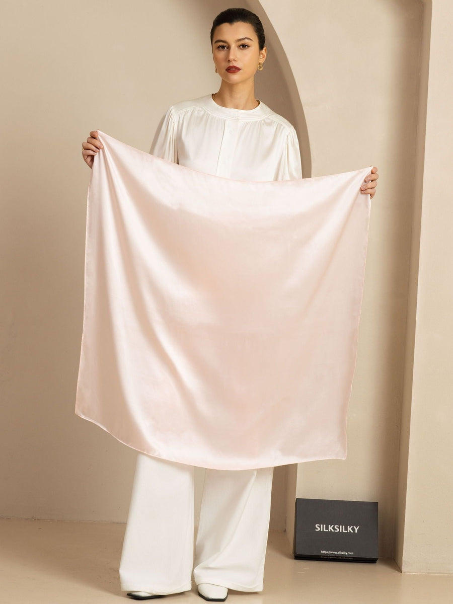 Elegant women's blush pink 100% mulberry silk square scarf, 90x90cm, held by a model.