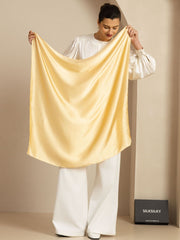 Elegant champagne mulberry silk square scarf held by a woman, 90x90cm.