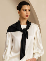 Elegant black mulberry silk square scarf, 90x90cm, tied around a woman's neck over a white blouse.