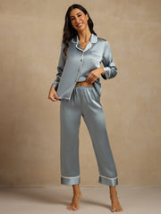 Women's mulberry silk pajama set in dusty blue with white contrast piping, long sleeve top and pants.