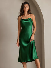 Woman in a green mulberry silk cowl neck midi dress with thin straps.