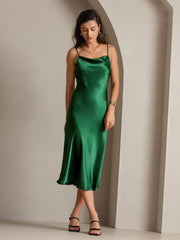 Woman in a green mulberry silk cowl neck midi dress with spaghetti straps.