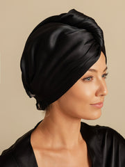 Woman wearing a black mulberry silk hair towel wrap, styled as a turban.