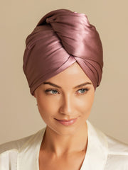 Woman wearing a mulberry silk hair towel wrap in a soft rose color, twisted style.