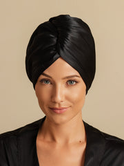 Black mulberry silk hair towel wrap on a woman, featuring a twisted front design.