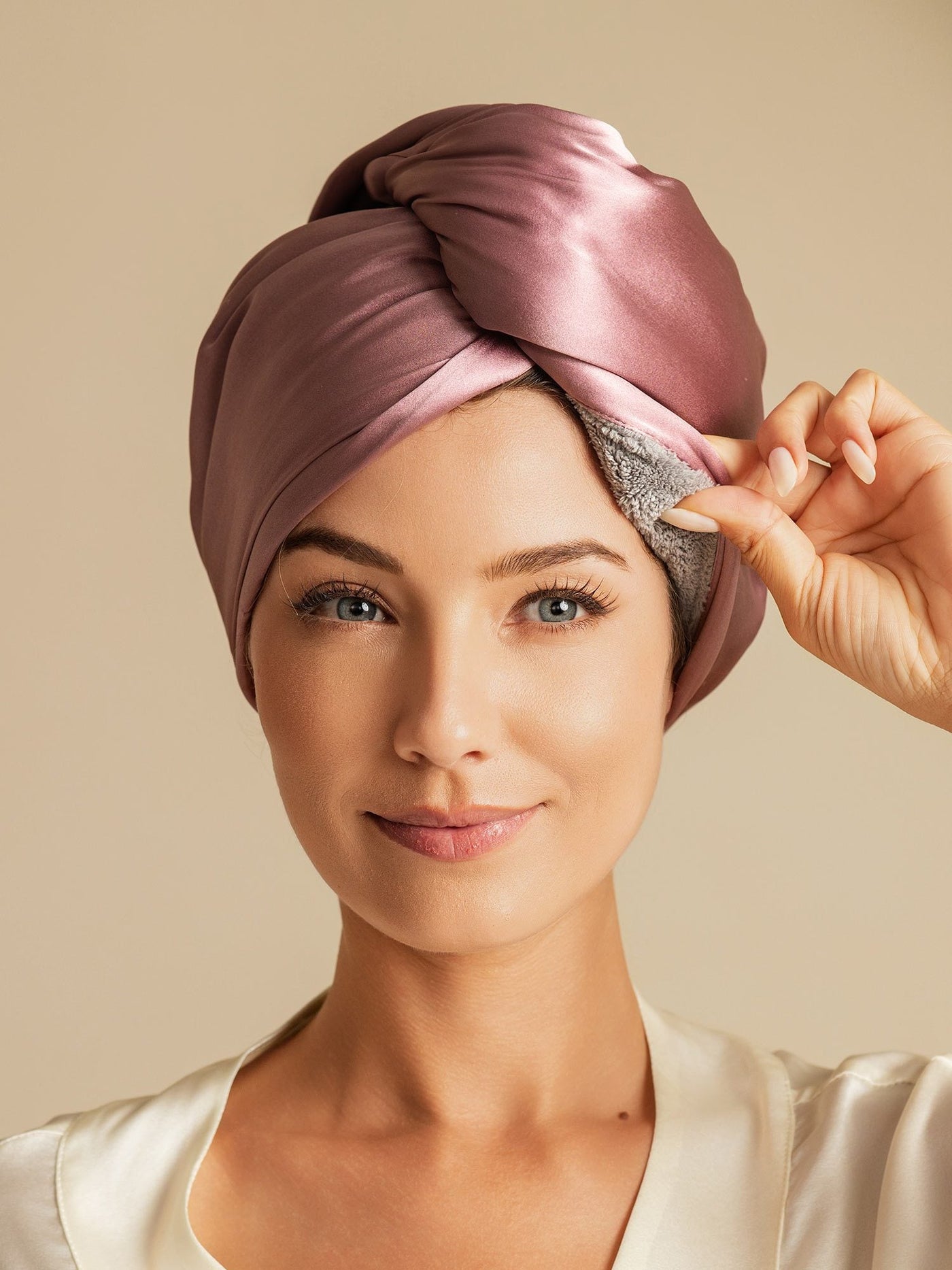 Woman wearing a pale mauve mulberry silk double-sided hair towel wrap, showing the soft inner lining.