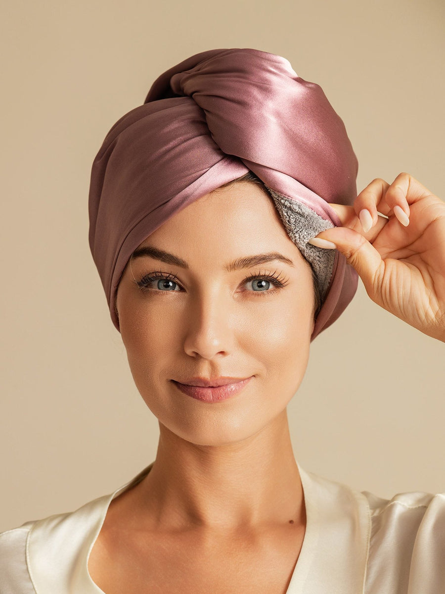 Woman wearing a pale mauve mulberry silk double-sided hair towel wrap, showing the soft inner lining.
