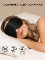Woman wearing a black 100% Mulberry silk sleep eye mask with elastic band, lying on a white pillow.