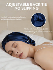 Navy blue mulberry silk bonnet with adjustable back tie, worn by a woman sleeping.