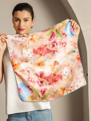 Woman holding a 53x53cm 100% mulberry silk floral bliss square scarf with vibrant red and pink flowers.