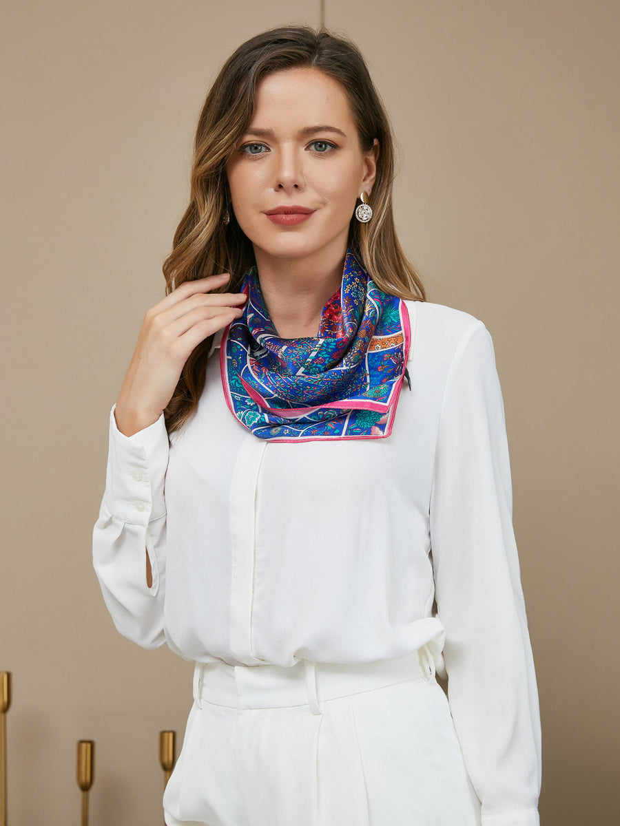 Woman wearing a blue mulberry silk floral pattern scarf, 53x53cm, with a white shirt.
