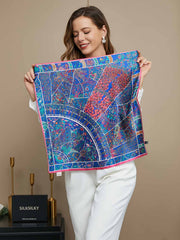 Blue 100% Mulberry silk floral pattern scarf with pink border, held by a woman.