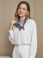 Woman wearing a blue and pink floral mulberry silk scarf, 53x53cm, tied around her neck.