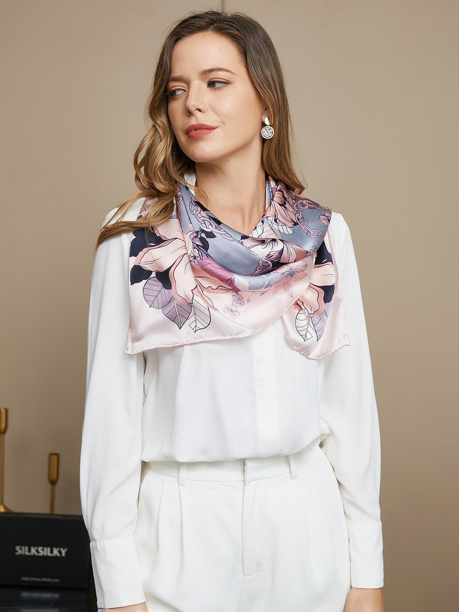 Mulberry silk floral pattern square scarf in pink and grey, worn by a woman in a white shirt.