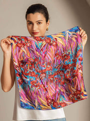 Woman holding a vibrant mulberry silk floral pattern square scarf, 53x53cm.