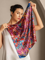 Woman holding a vibrant mulberry silk floral pattern square scarf.