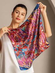 Woman holding a vibrant mulberry silk floral pattern square scarf, 53x53cm.