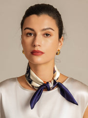 Woman wearing a mulberry silk floral square scarf with navy blue and white accents.