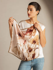 Mulberry silk floral square scarf with gold trim, held by a woman.
