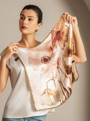 Mulberry silk floral square scarf with gold trim, held by a woman.