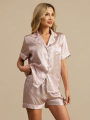Women's pink mulberry silk short sleeve pajamas with a geometric heart print and white piping.