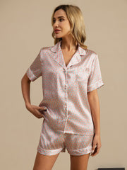 Women's mulberry silk short sleeve pajamas set with pink and teal geometric print and white piping.