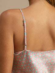 Women's mulberry silk camisole with pink geometric print and spaghetti straps.