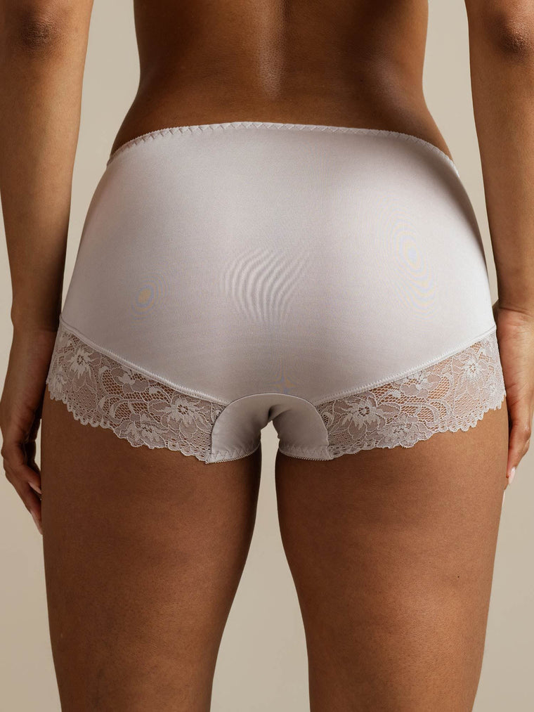 Light grey mulberry silk high-rise knickers with white lace trim, seen from behind on a model.