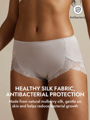 Light gray mulberry silk high-rise knickers with delicate lace trim, worn by a woman.
