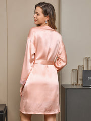Women's pink mulberry silk robe with lace trim on sleeves, tied at waist.