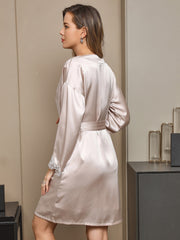 Women's blush pink mulberry silk robe with white lace cuffs and a tie waist.