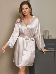 Women's champagne mulberry silk robe with lace trim on sleeves, tied at waist.