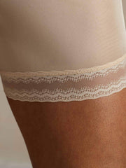 Nude mulberry silk anti-chafing shorts with delicate lace trim on a woman's thigh.