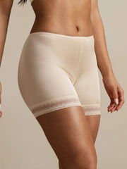 Nude mulberry silk anti-chafing shorts with delicate lace trim, worn by a woman.