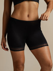 Black mulberry silk anti-chafing shorts with delicate lace trim on a woman.