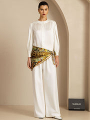 Woman in white outfit with a 90x90cm mulberry silk leopard & floral scarf tied at the waist.