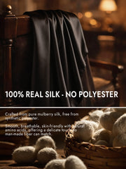 Smooth black mulberry silk long scarf draped over a wooden chair.